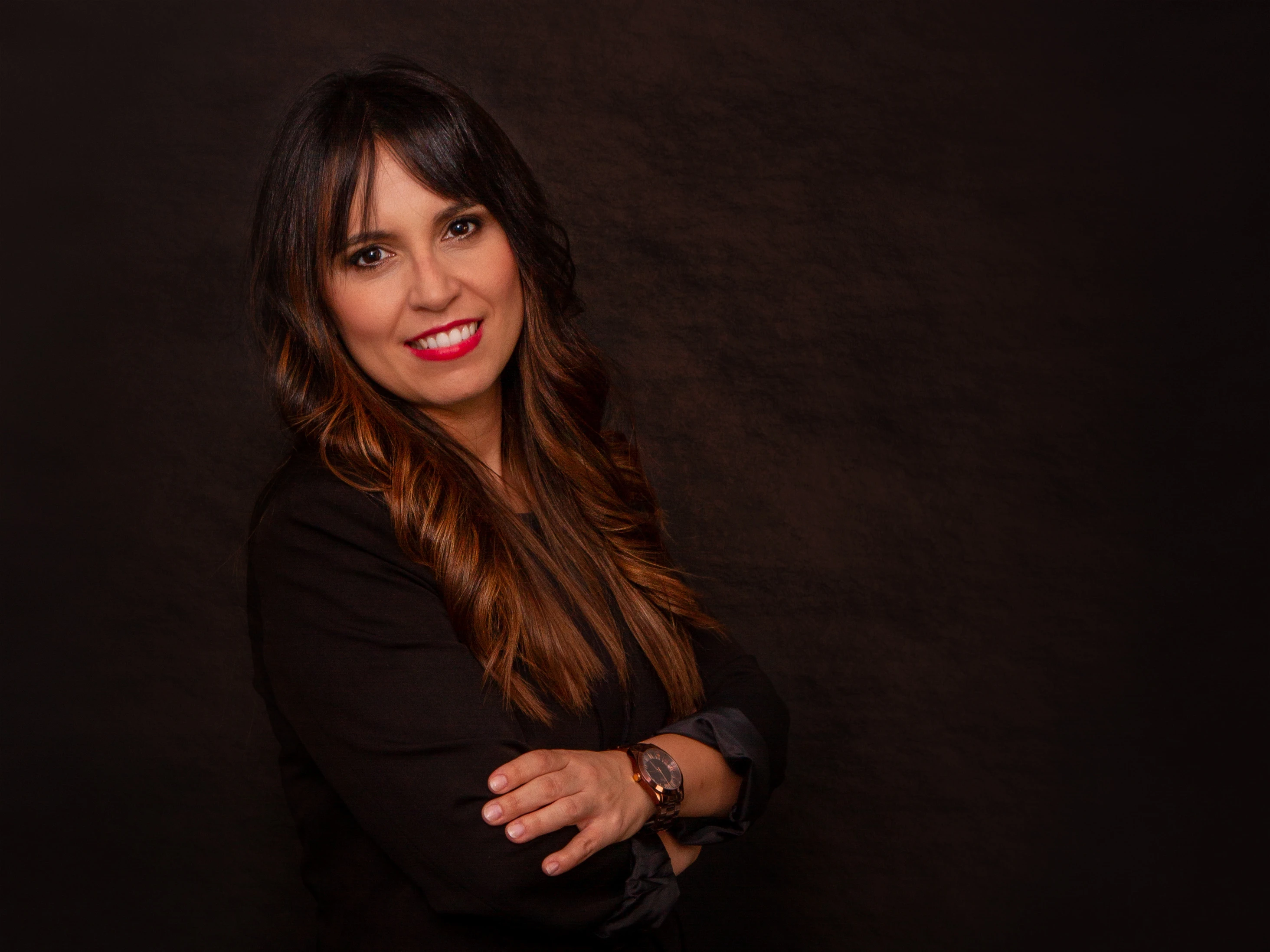 Almudena Lebrero, psicóloga sanitaria, con los brazos cruzados sobre fondo oscuro