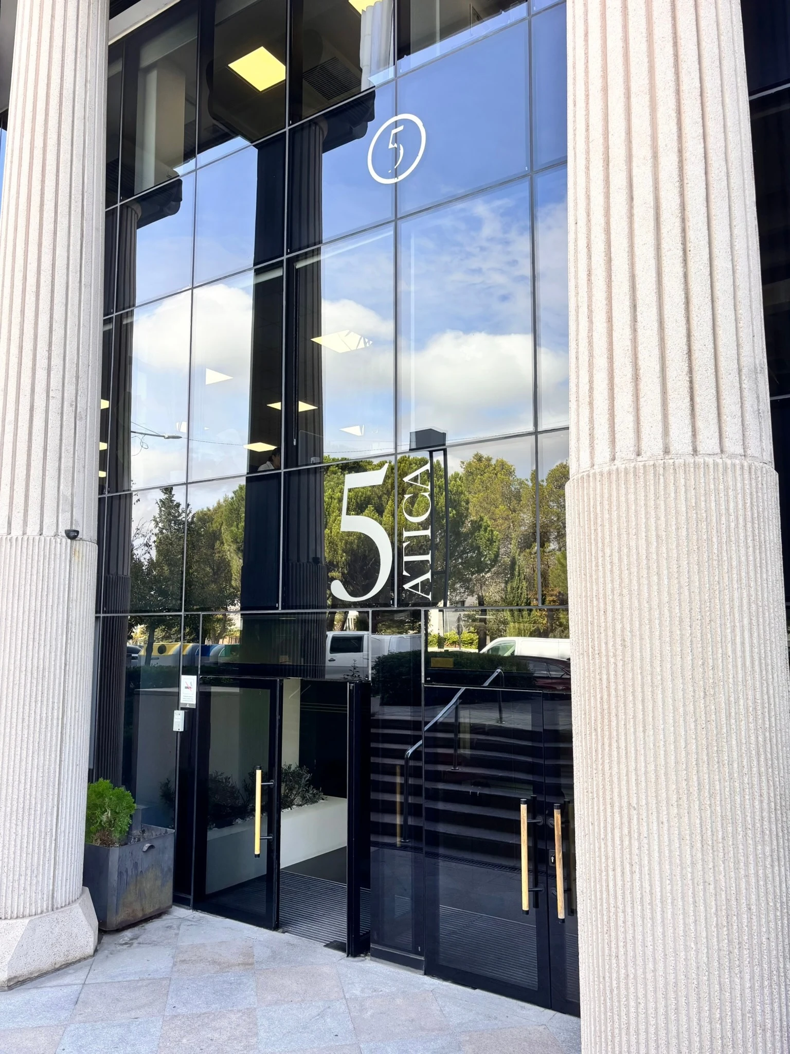 Portal del Edificio Ática 5, con el rótulo 5 Ática sobre las puertas de cristal
